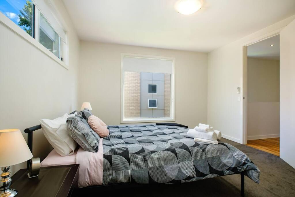 a bedroom with a large bed and a window at Splendour on Sackville in Albury