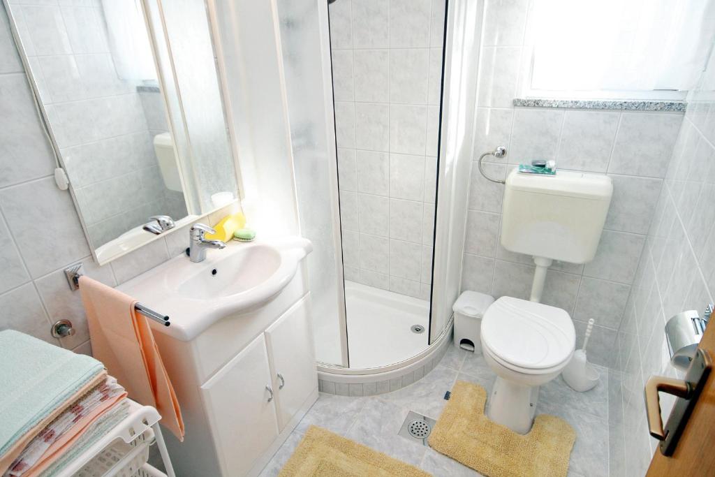łazienka z prysznicem, toaletą i umywalką w obiekcie Apartments by the sea Kali, Ugljan - 5828 w mieście Kali