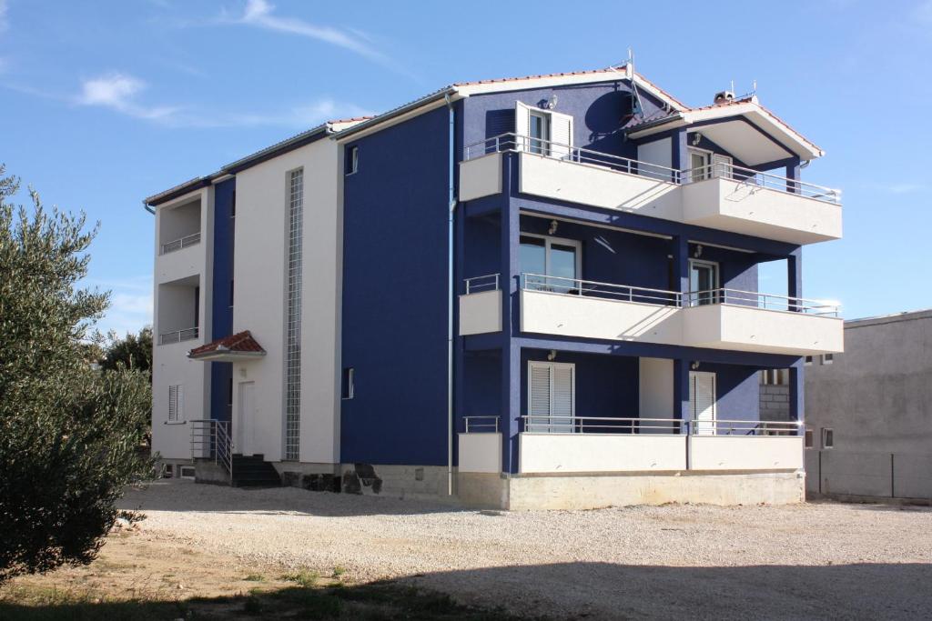 ein blaues Gebäude mit einem Balkon an der Seite in der Unterkunft Apartments by the sea Bibinje, Zadar - 5916 in Bibinje