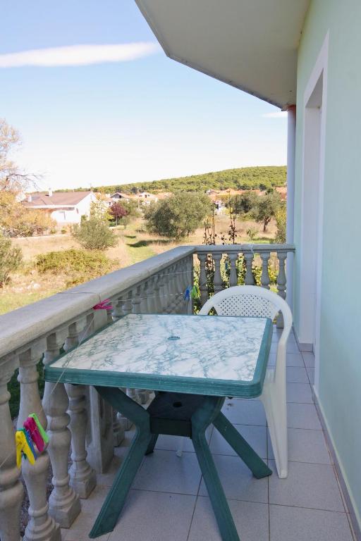 a table on a balcony with a view of the ocean at Apartments with a parking space Bibinje, Zadar - 5753 in Bibinje