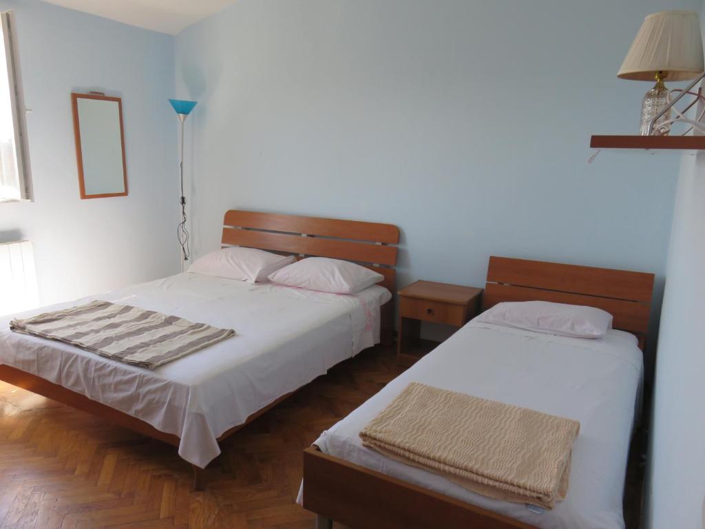 a bedroom with two beds and a lamp at Apartments with a parking space Bibinje, Zadar - 5753 in Bibinje