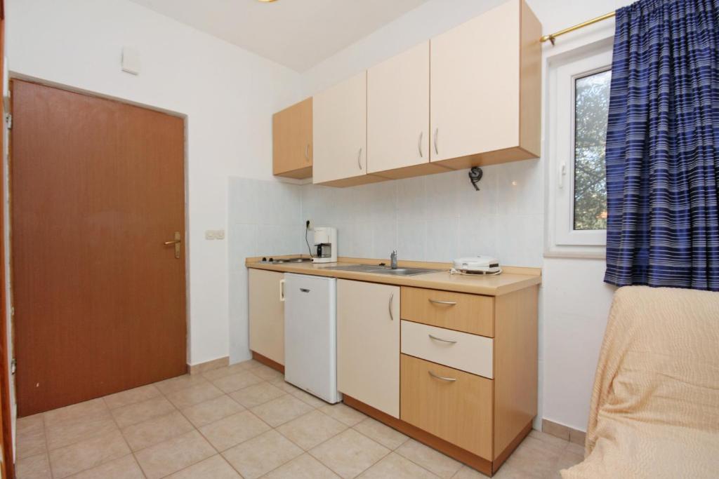a kitchen with white cabinets and a sink and a window at Apartments with a parking space Bibinje, Zadar - 5753 in Bibinje