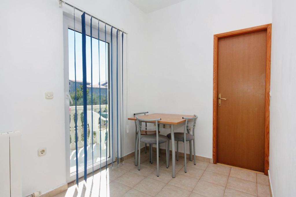 a table and chairs in a room with a window at Apartments with a parking space Bibinje, Zadar - 5753 in Bibinje