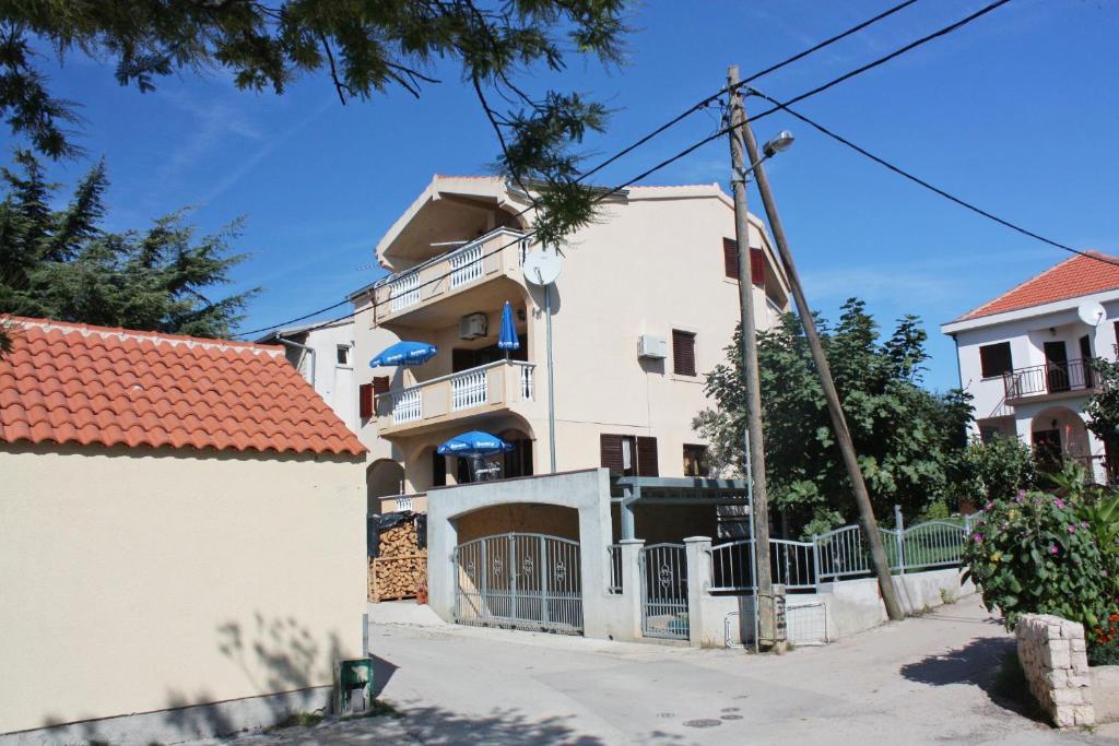una casa blanca con una puerta y una valla en Apartments by the sea Bibinje, Zadar - 5769 en Bibinje