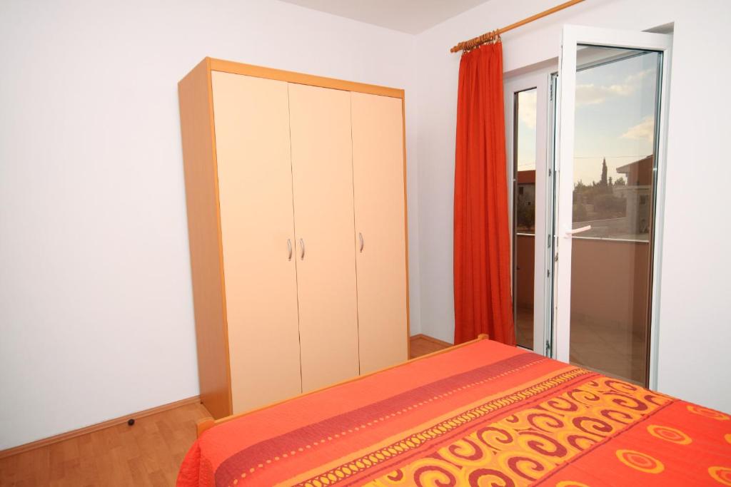 sypialnia z łóżkiem i przesuwanymi drzwiami szklanymi w obiekcie Apartment Vrsi - Mulo 5860c w Nin