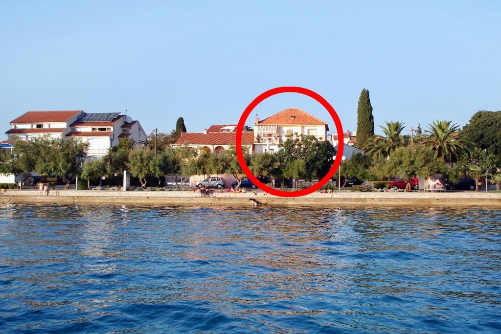 een rode cirkel aan de kust van een strand bij Apartments by the sea Zadar - Diklo, Zadar - 5911 in Zadar
