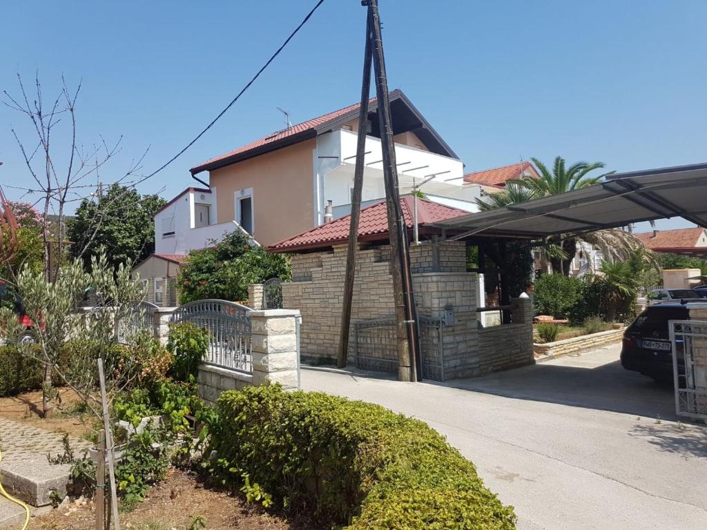 une maison avec une clôture en face d'une allée dans l'établissement Apartments with a parking space Sukosan, Zadar - 5820, à Sukošan