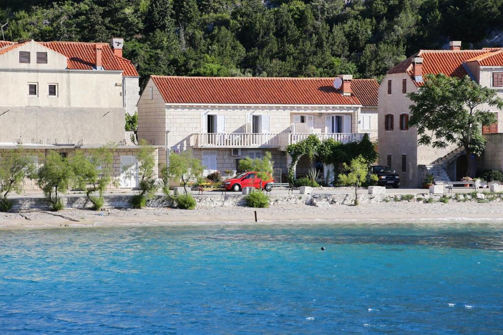 a group of houses on the shore of the water at Apartments by the sea Trstenik, Peljesac - 4570 in Trstenik