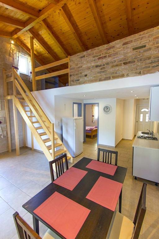 kuchnia i jadalnia ze stołem i schodami w obiekcie Apartment Skozanje 5713d w mieście Gdinj