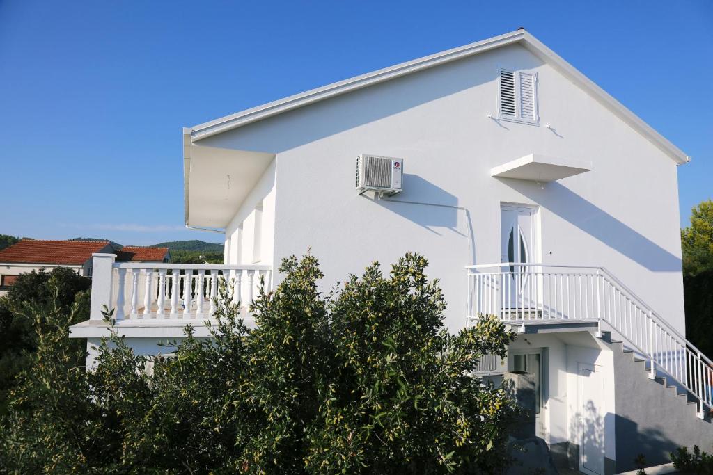 a white house with white balconies and trees at Apartments with a parking space Zavalatica, Korcula - 4459 in Zavalatica