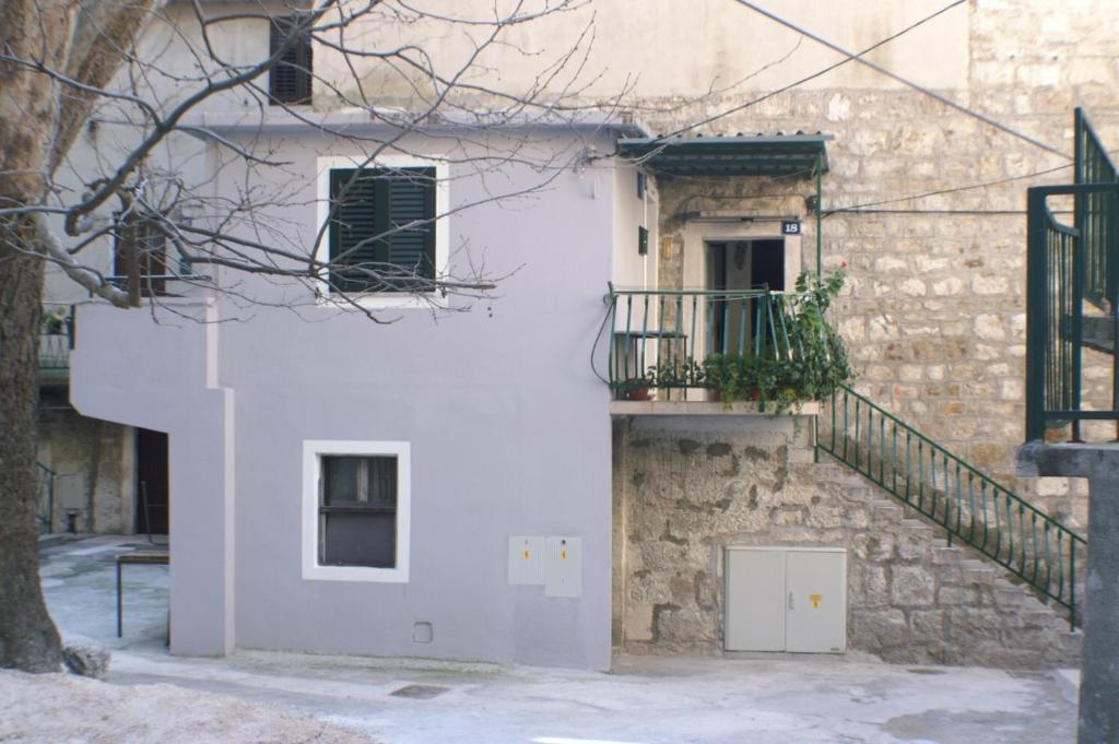 a white building with a staircase and a door at Apartments with a parking space Omis - 4327 in Omiš