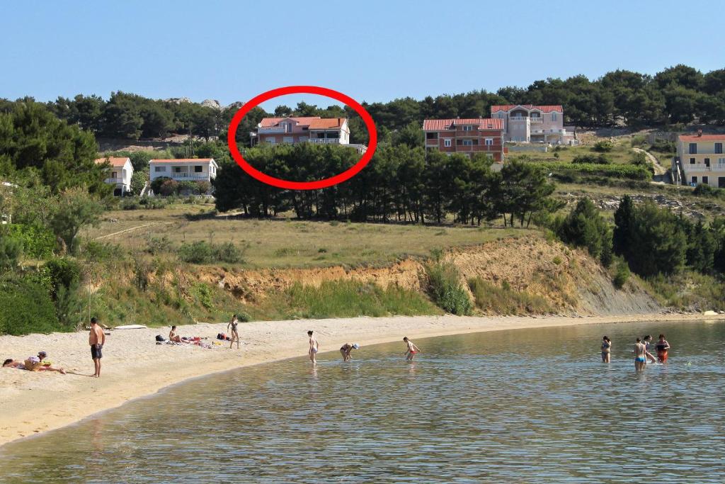 a group of people on a beach near the water at Apartment Vlasici 4319a in Vlašići
