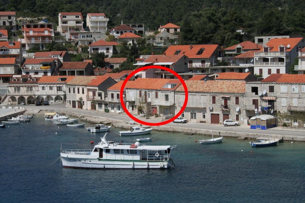 a boat in the water next to a city at Apartments by the sea Brna, Korcula - 4415 in Smokvica