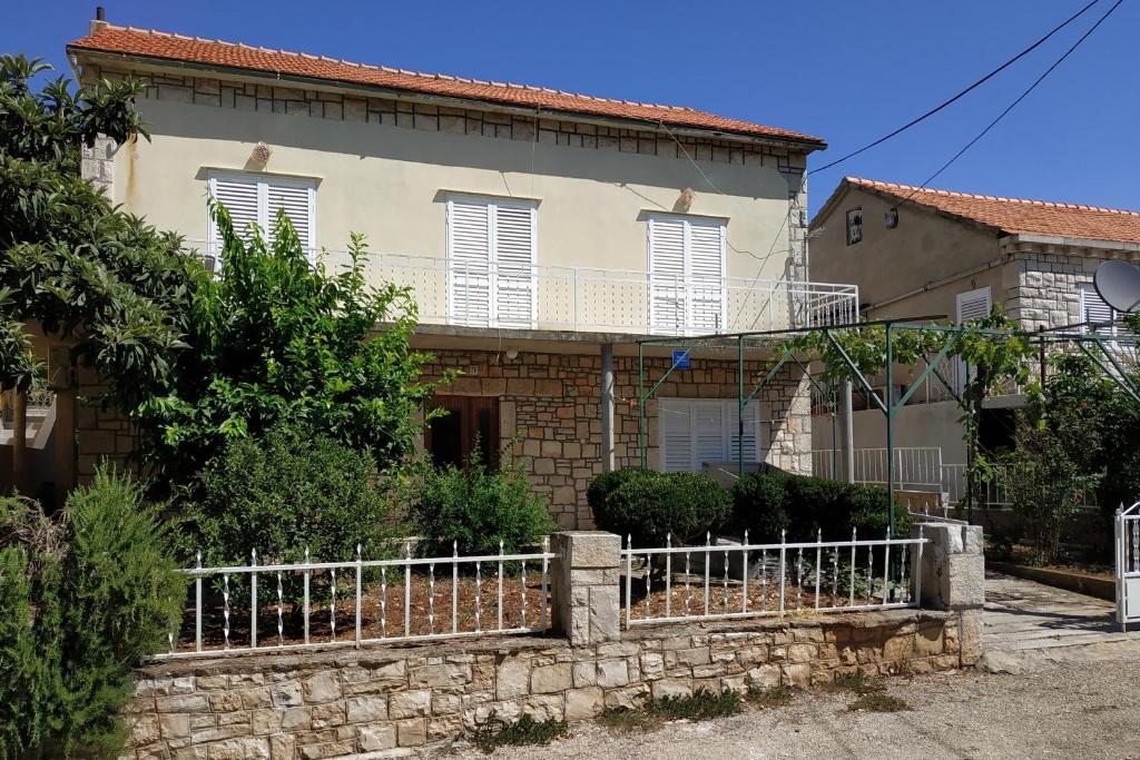 ein Haus mit einem Zaun davor in der Unterkunft Apartment Brna 4468a in Brna