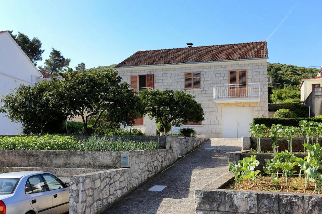 dom z samochodem zaparkowanym przed nim w obiekcie Apartments by the sea Zrnovska Banja, Korcula - 4363 w Korčuli