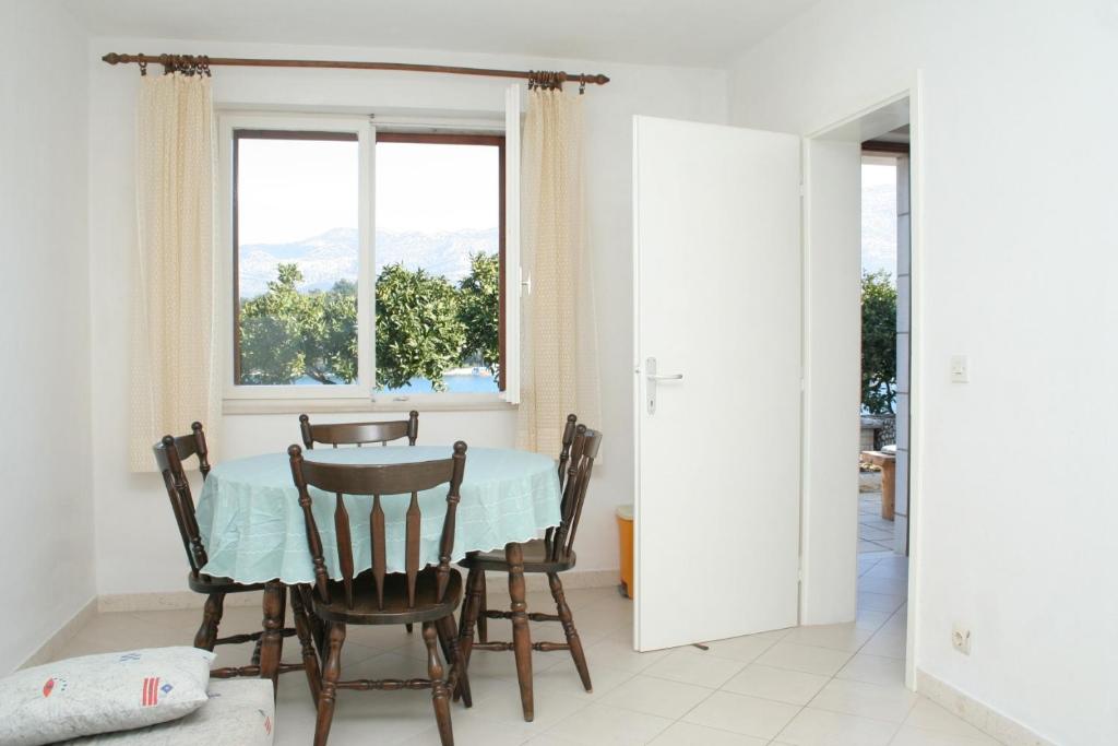 jadalnia ze stołem i krzesłami oraz oknem w obiekcie Apartments by the sea Zrnovska Banja, Korcula - 4363 w Korčuli