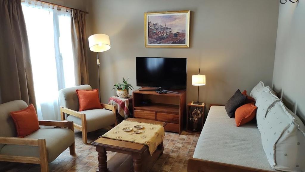 - un salon avec un canapé et une télévision dans l'établissement Casita Cavok, à San Carlos de Bariloche