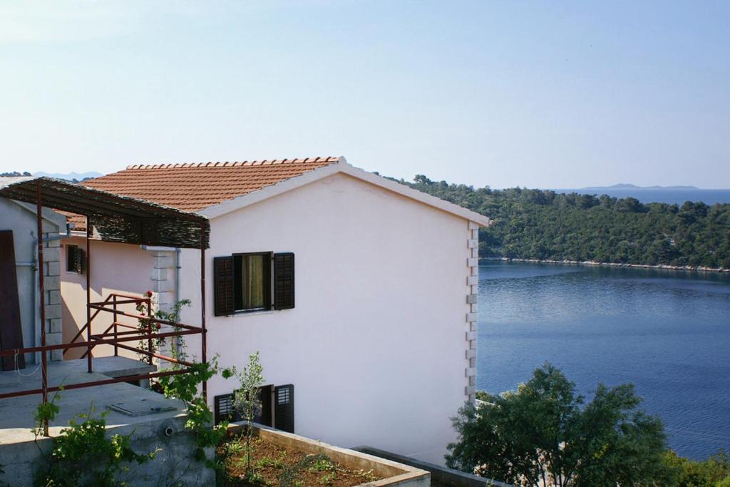 a white building with a view of a lake at Apartments by the sea Karbuni, Korcula - 4465 in Prizba