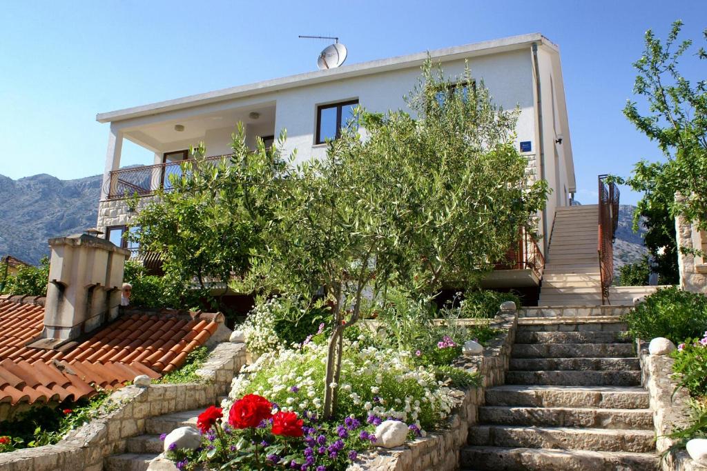 una casa con escaleras y flores delante en Studio Orebic 4496d en Orebić