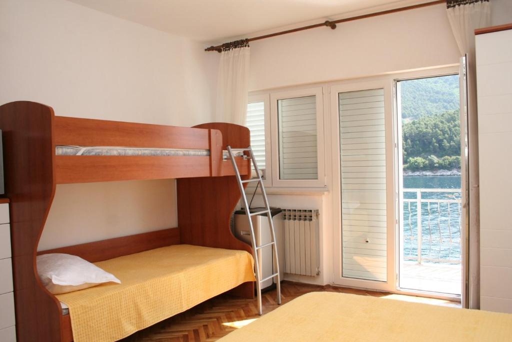 a bedroom with two bunk beds and a window at Studio Trstenik 4566b in Trstenik
