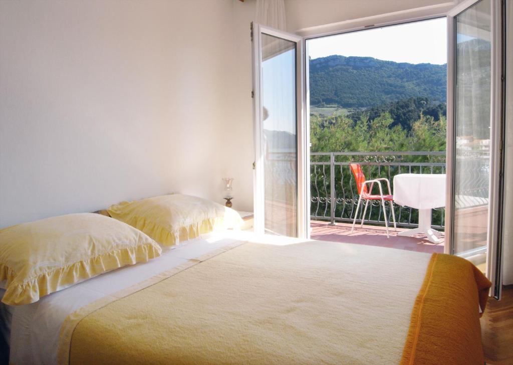 a bedroom with a bed and a balcony with a view at Apartments and rooms by the sea Trstenik, Peljesac - 4566 in Trstenik