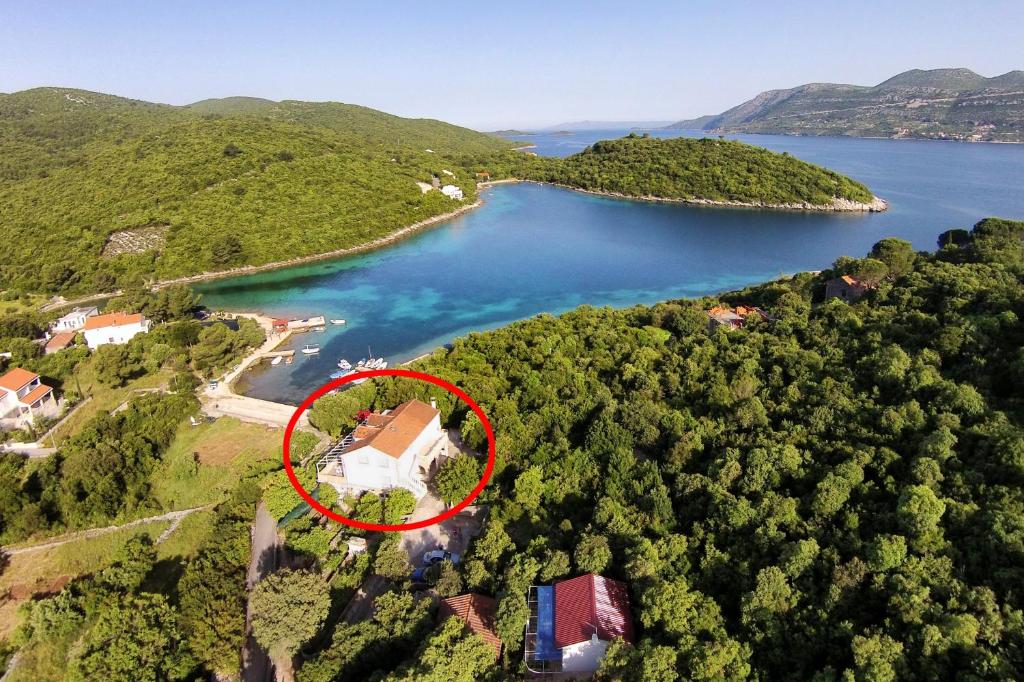 an island with a house in the middle of a lake at Apartments by the sea Cove Vrbovica bay - Vrbovica (Korcula) - 4452 in Korčula