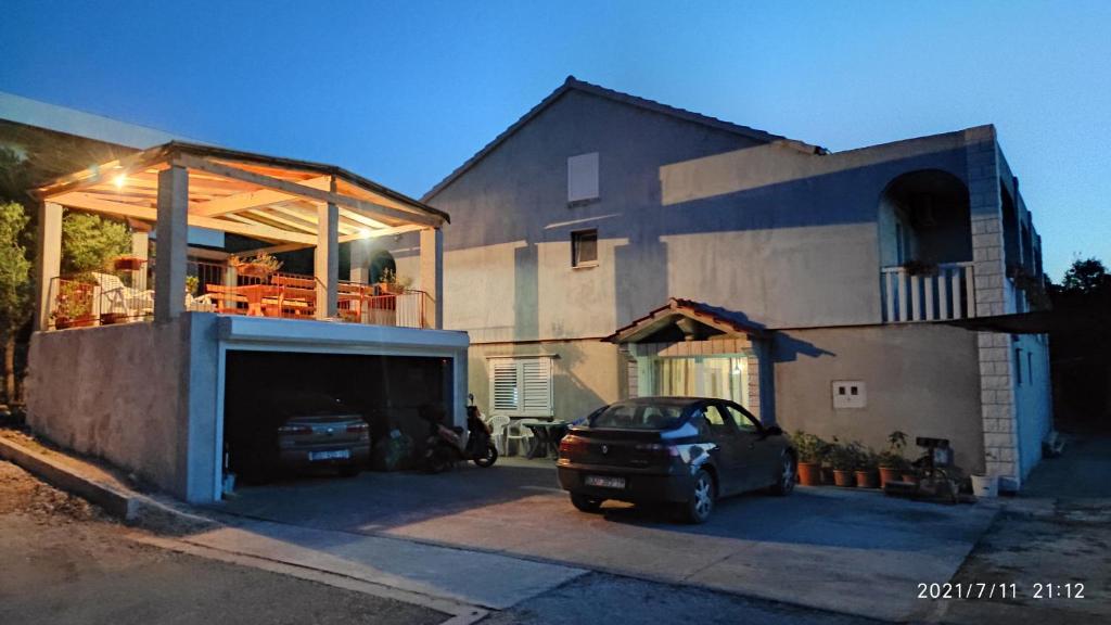 a car parked in a parking lot in front of a house at Apartment Kneza 4342a in Račišće