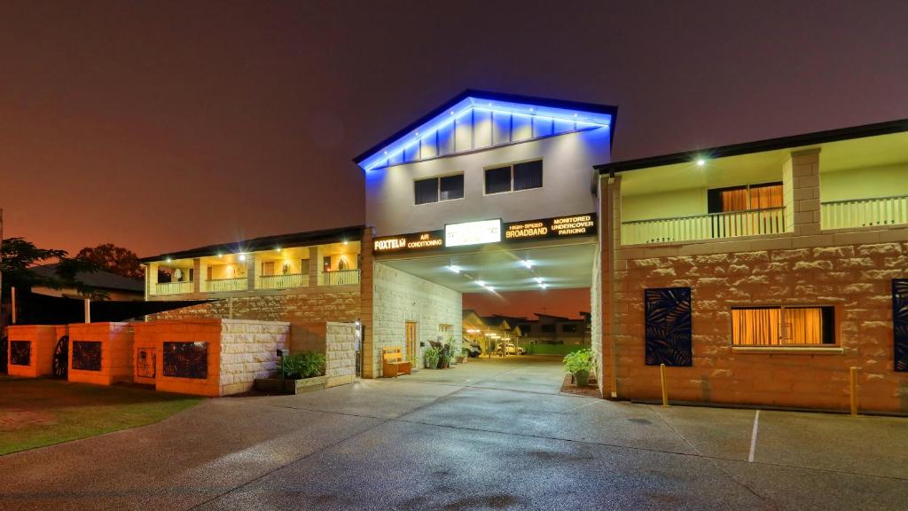 Best Western Caboolture Gateway Motel في كابولتشر: مبنى عليه ضوء أزرق في الليل
