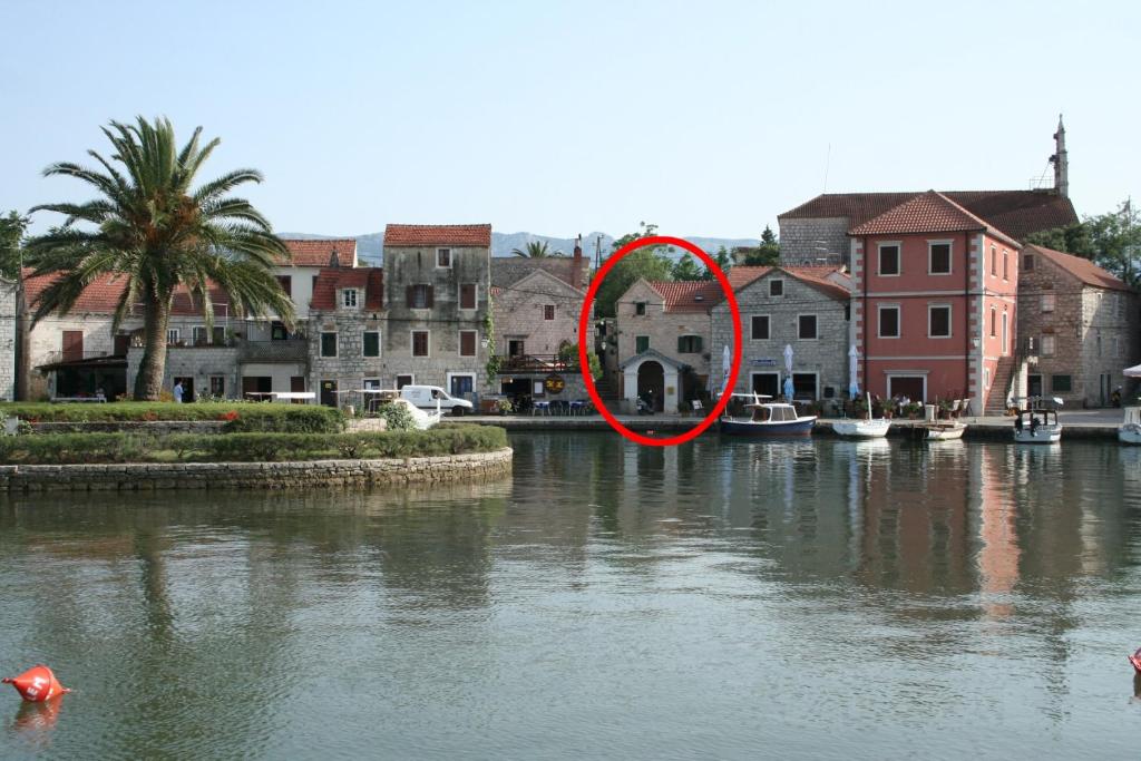 un oggetto rosso nell'acqua accanto a un fiume di Apartment Vrboska 4601c a Vrboska (Verbosca)