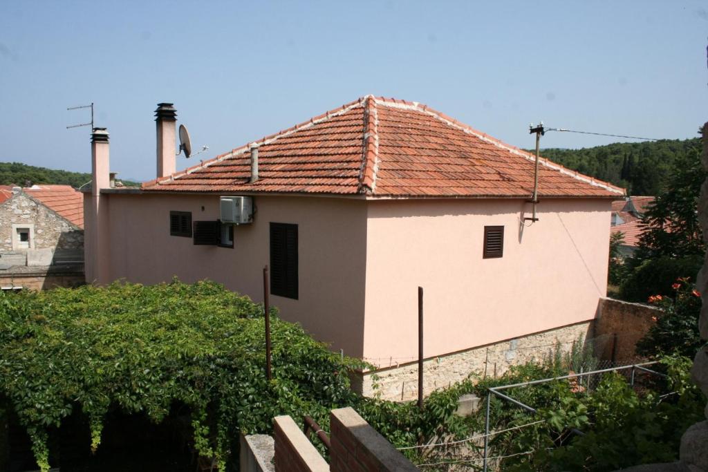 une maison blanche avec un toit rouge dans l'établissement Rooms by the sea Vrboska (Hvar) - 4600, à Vrboska