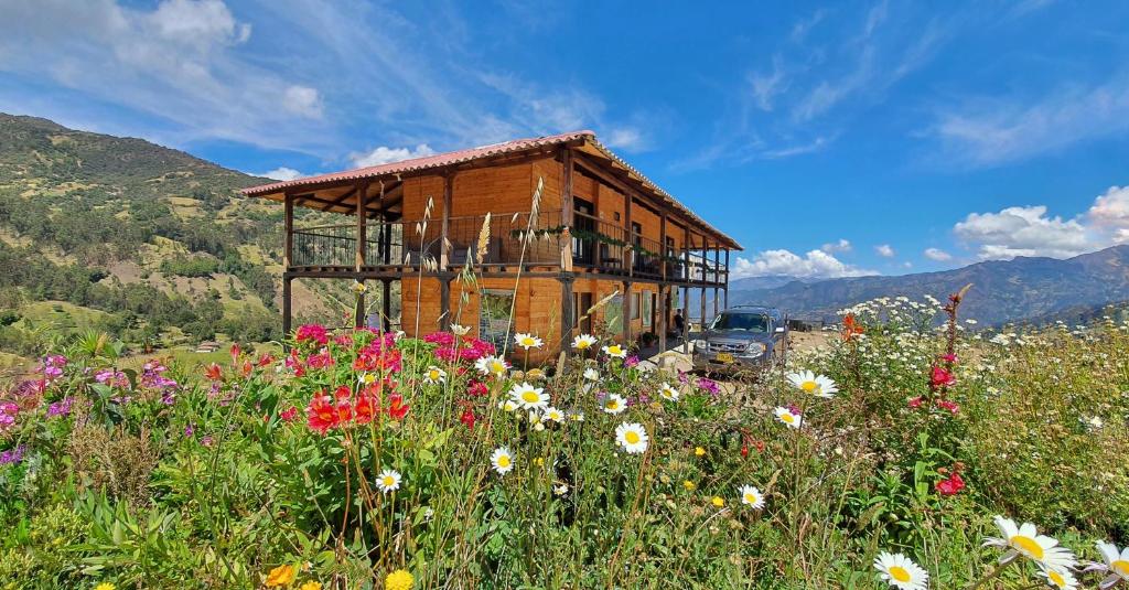 un edificio de madera en un campo de flores en Balcones de El Carrizal, en El Cocuy