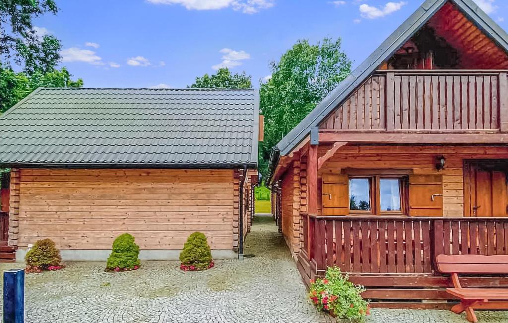 a wooden cabin with a bench next to it at 2 Bedroom Cozy Home In Jaroslawiec in Jarosławiec