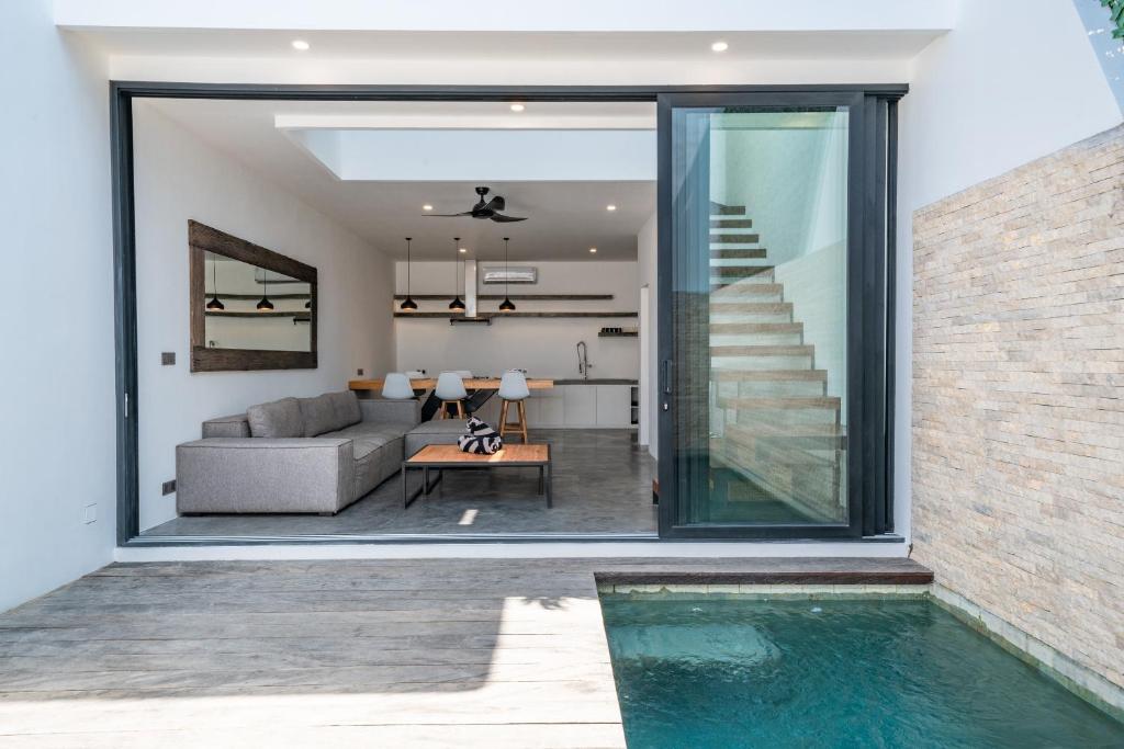 una sala de estar y una piscina en una casa en Loft Charly - Contemporary 1-bdr luxury loft in GREAT LOCATION, en Canggu