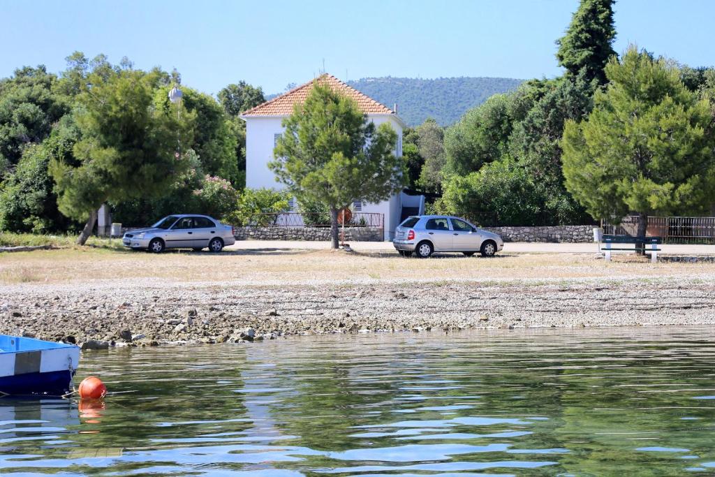 two cars parked next to a body of water at Family Room Drace 4550a in Drače