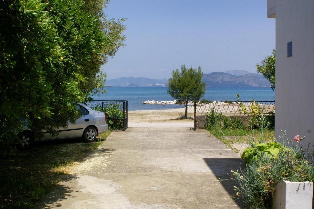 a car parked on the side of a sidewalk near the ocean at Family Room Drace 4550a in Drače