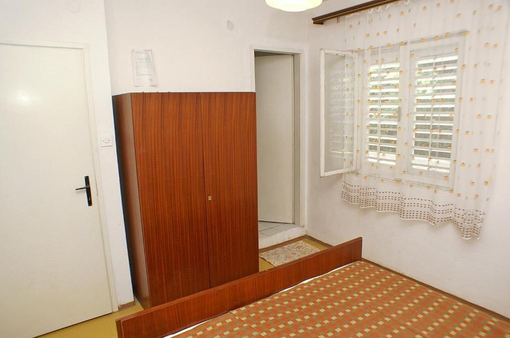 a room with a bed and a door and a window at Family Room Drace 4550a in Drače
