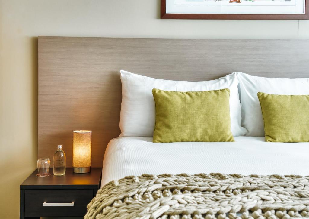 um quarto com uma cama grande e almofadas amarelas em The Point Brisbane Hotel em Brisbane