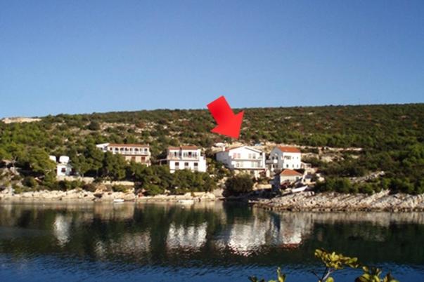a red object is flying in the air over a body of water at Family friendly seaside apartments Cove Jagodna - Brusje, Hvar - 4606 in Brusje