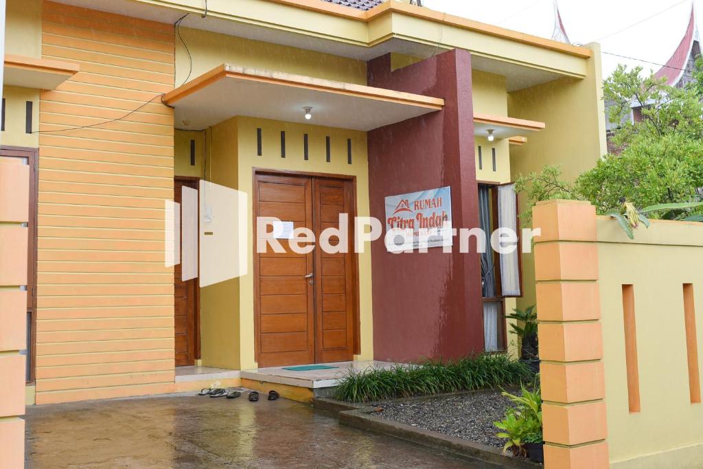 ein rotes Partnerschild an der Seite eines Hauses in der Unterkunft Homestay Rumah Citra Indah Syariah Mitra RedDoorz in Bukittinggi