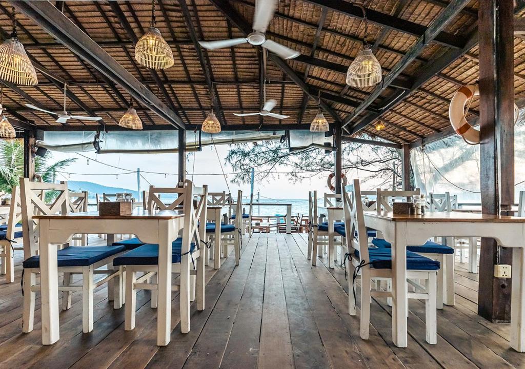 a restaurant with tables and chairs and a view of the ocean at Sara Resort in Koh Rong Sanloem
