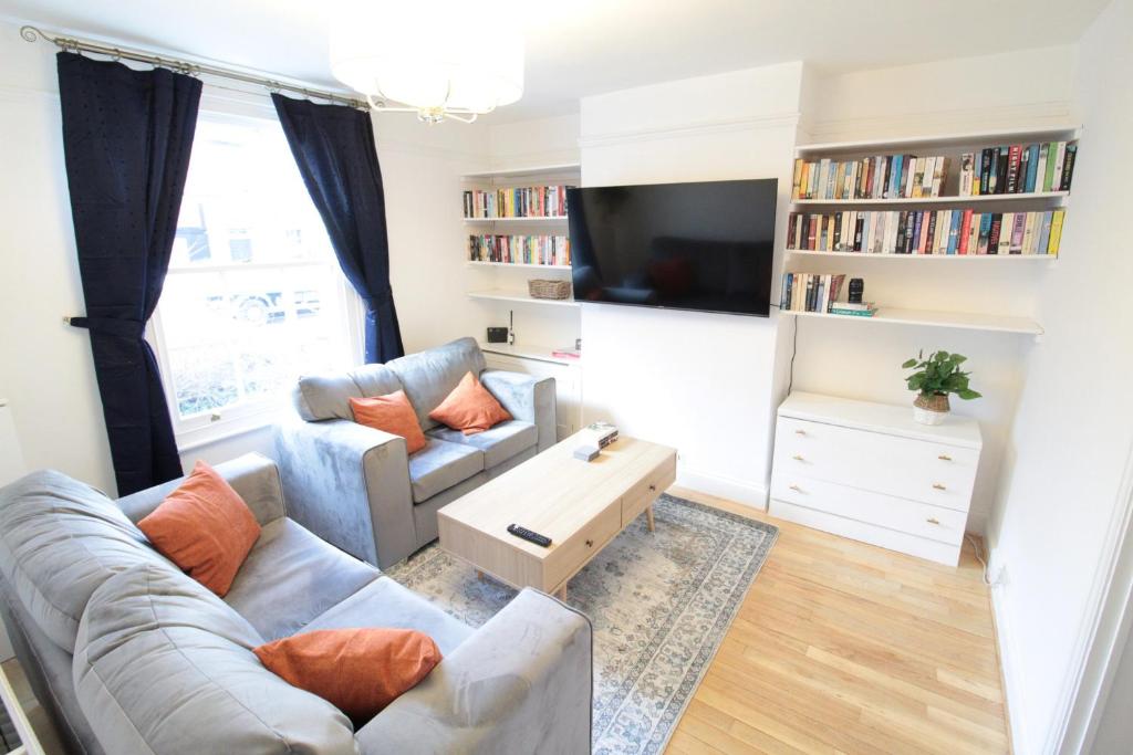 a living room with a couch and a tv at Alma House by 360Stays - Private Garden, Free Parking, Close to Oxford City Centre with Parking in Oxford
