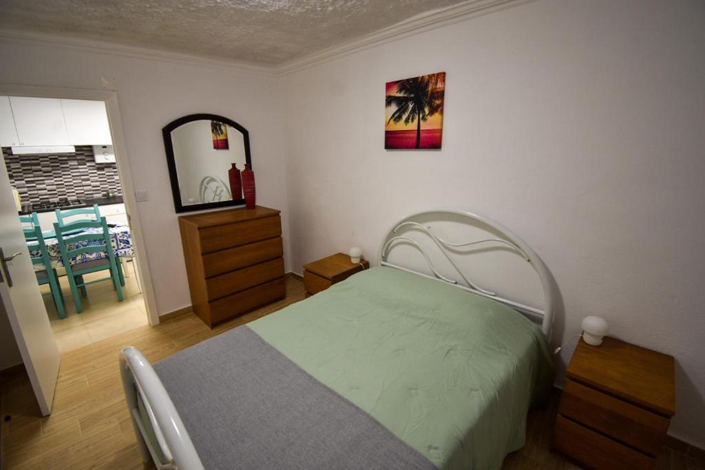 a bedroom with a bed and a dresser and a mirror at Rock´s Beach Spot in Costa da Caparica