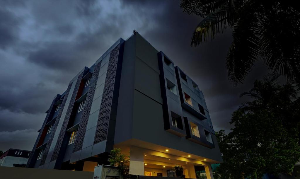 un edificio con sus luces encendidas por la noche en UPAR Hotels Thoraipakkam, OMR, en Chennai