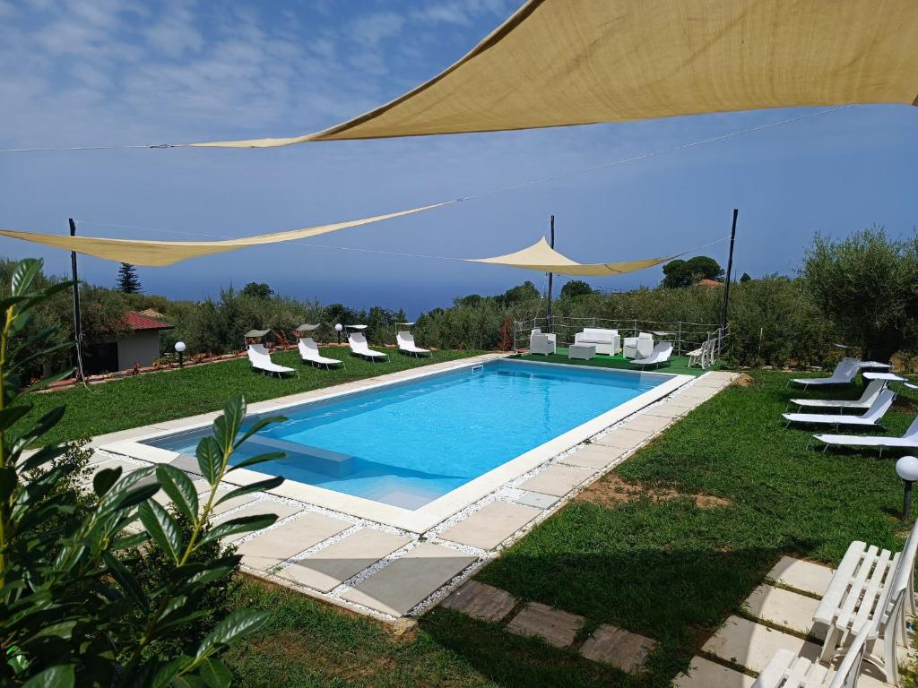 einen Pool mit Stühlen und einem großen Sonnenschirm in der Unterkunft Casa Vacanze Nino Petrelli in Naso