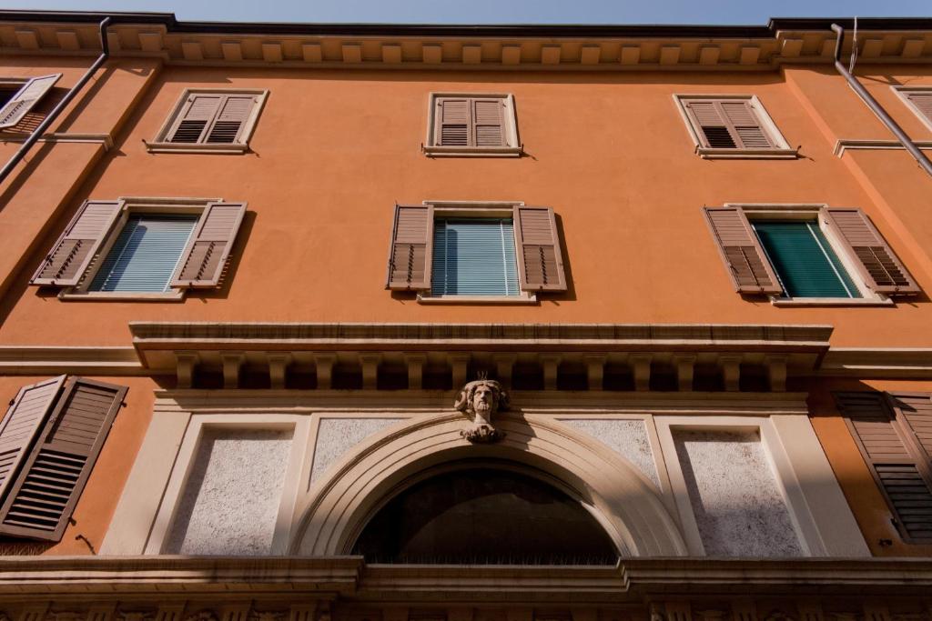 ein Gebäude mit blauen Fensterläden und einem Bogen in der Unterkunft B&B Principe all'Arena in Verona