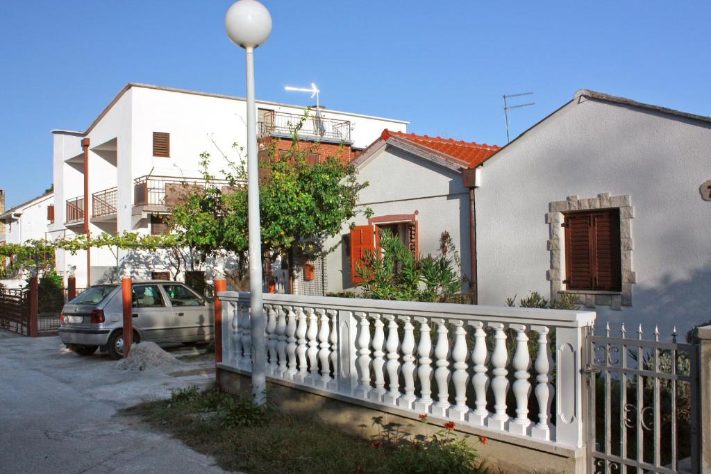 a street with houses and a white fence at Apartments with a parking space Sabunike, Zadar - 5822 in Privlaka