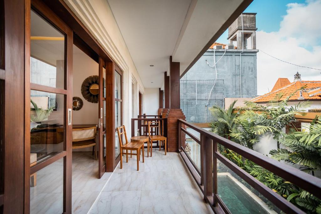 a balcony with a table and chairs and a dining room at Tamantara in Ubud