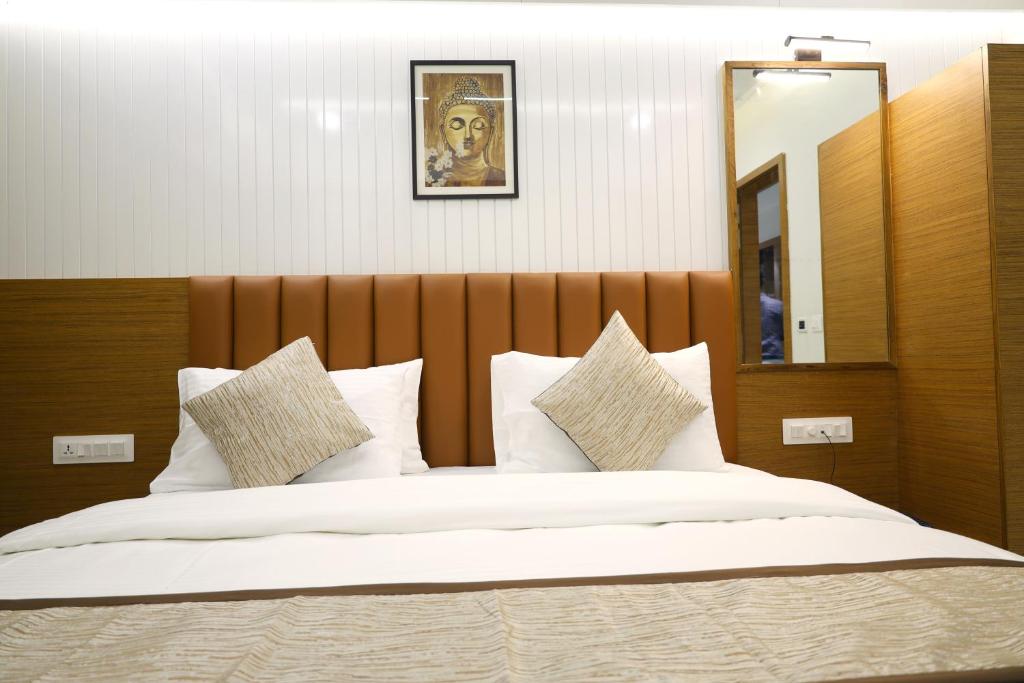 a bedroom with a large bed with white pillows at Tulsi Hotel in Surat