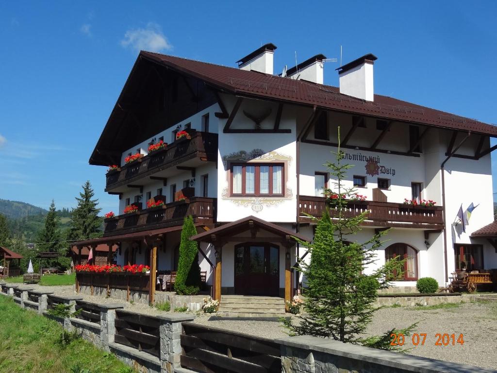 a large white building with flowers on the balconies at Alpenhof Pansion in Slavske