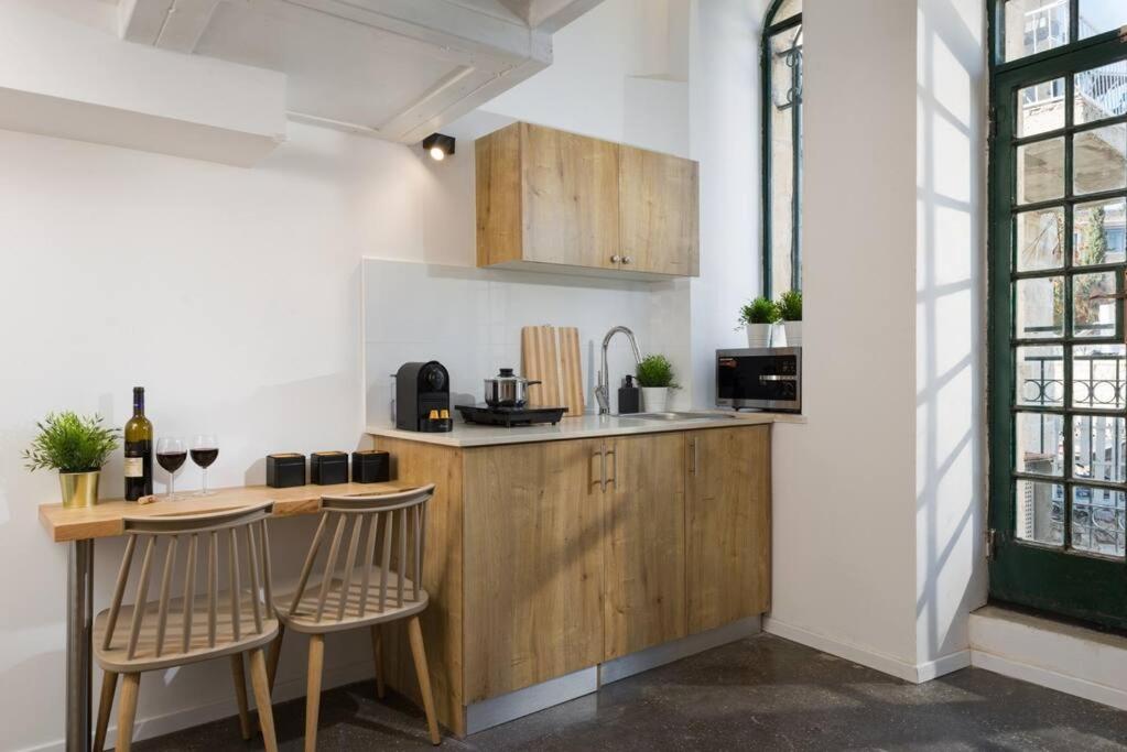 a kitchen with a wooden counter and two chairs at Musrara #3 in Jerusalem